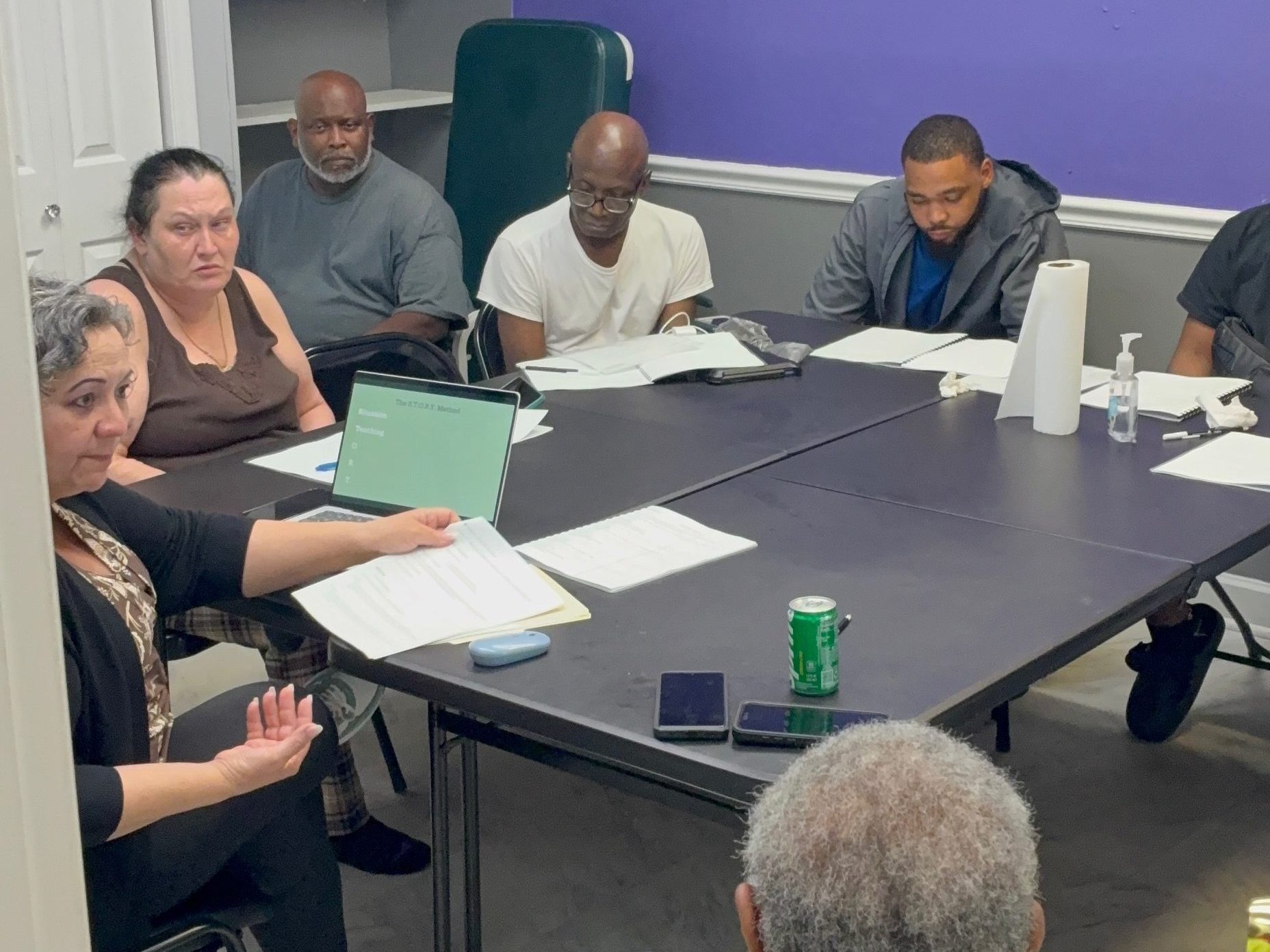 Caregiver training session with participants seated around a conference table.